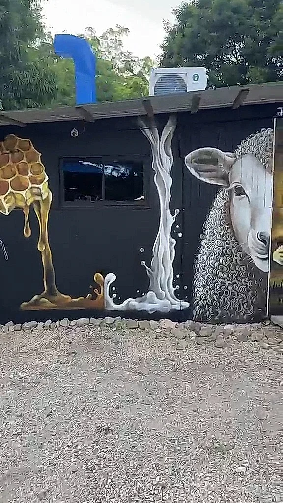 Mural de miel y leche cayendo junto a un cordero